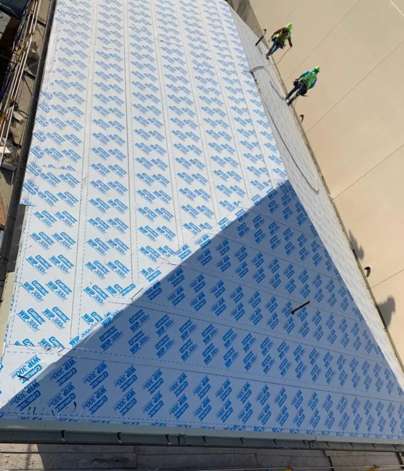 Professional roofers installing underlayment on a metal roof in Fitchburg